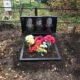 Небольшая горизонтальная гранитная стела на тройной могиле