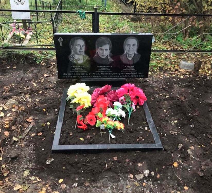 Небольшая горизонтальная гранитная стела на тройной могиле